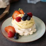 Mini Pavlova served with cheesecake mousse and fresh berries.