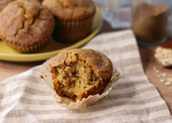 Chai Spiced Banana Muffin on a linen napkin with a bite taken so the interior crumb is visible.