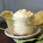 Lemon Mascarpone Cream swirled in a small jar with a spoon.