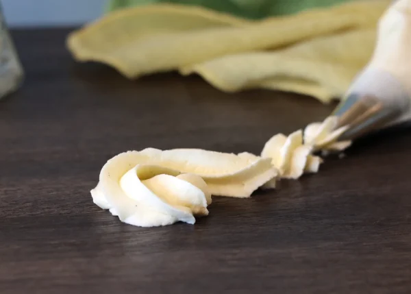 Lemon Mascarpone Cream piped in a small swirl showing its structure and ability to hold shape.