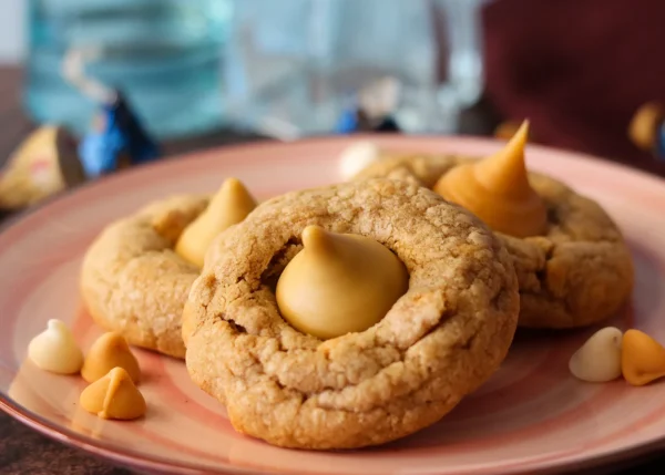 Three Butterbeer blossom cookies arranged on an apricot colored plate.